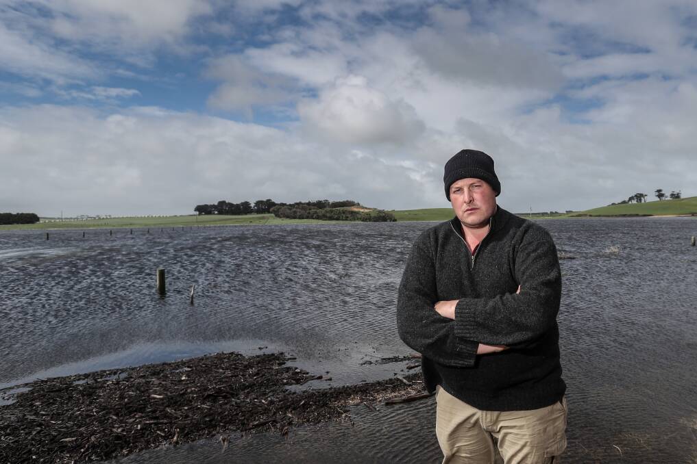WET: Ben Holloway stands in one of his paddocks, which has flooded due to a blocked drainage channel. The flooding will cost the Allansford dairy farmer upwards of $60,000.Picture: Christine Ansorge