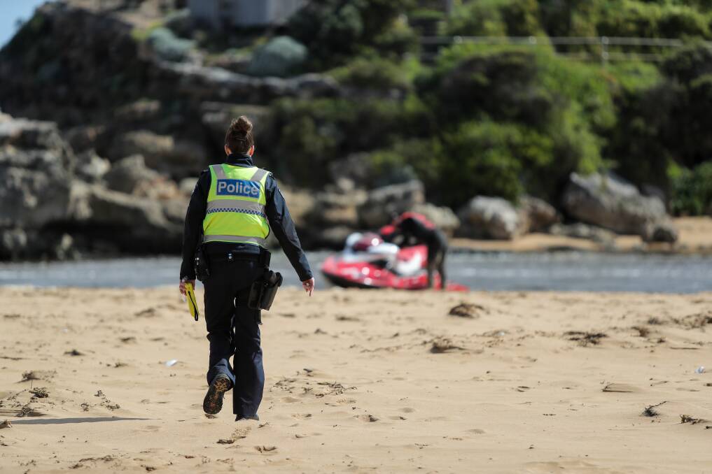 Police talk to a jet ski driver after he and a mate got into trouble off the beach at Bluehole. Picture: Rob Gunstone