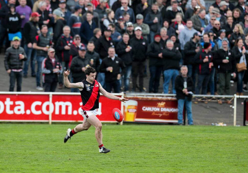BIG STAGE: Cobden's Angus Uwland kicks long in front of a big Hampden league preliminary final crowd at Reid Oval on Saturday. The Bombers crashed out of the premiership race. Picture: Rob Gunstone