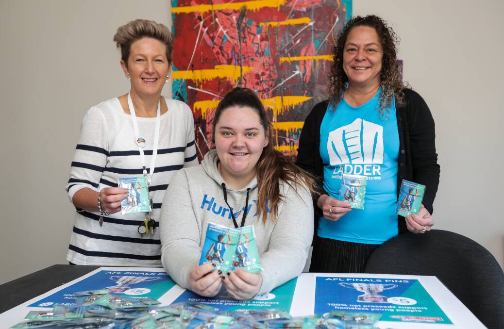 Good cause: Foyer's Jenny Hand, Tayla Hutchinson and Julie Poi-Kelly with pins to be sold at the HFNL grand final to tackle youth homelessness Picture: Rob Gunstone