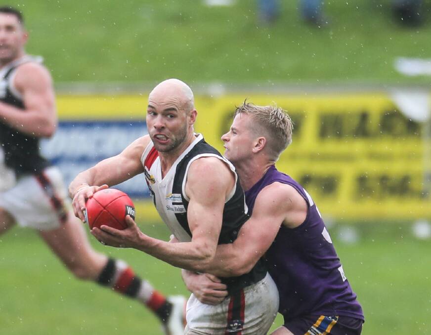BIG-GAME PERFORMER: Koroit assistant coach Damian O'Connor gets a handball away under pressure from Port Fairy's Kurt Smith. Picture: Rob Gunstone