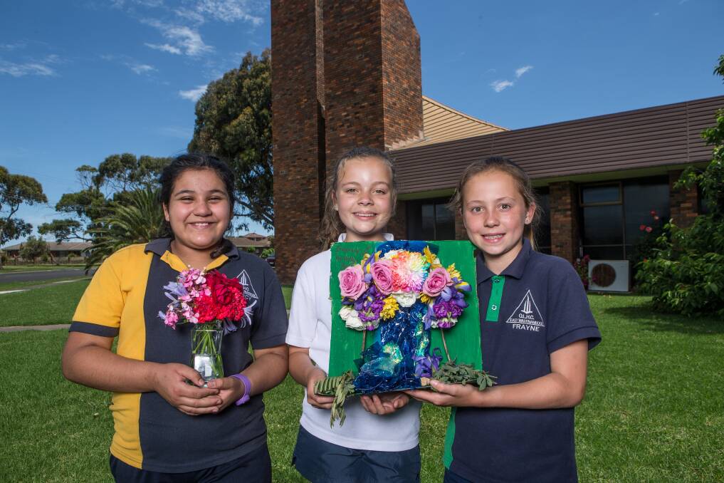 Flowers meet art: OLHC students Diana Fernandez, 11, Holly Uebergang, 11, and Bella Chow, 11 are gearing up for the 18th Rose and Floral Art weekend. They've sourced their inspiration from colours, shapes and whatever flowers they could find in the gardens of family and friends. Picture: Christine Ansorge