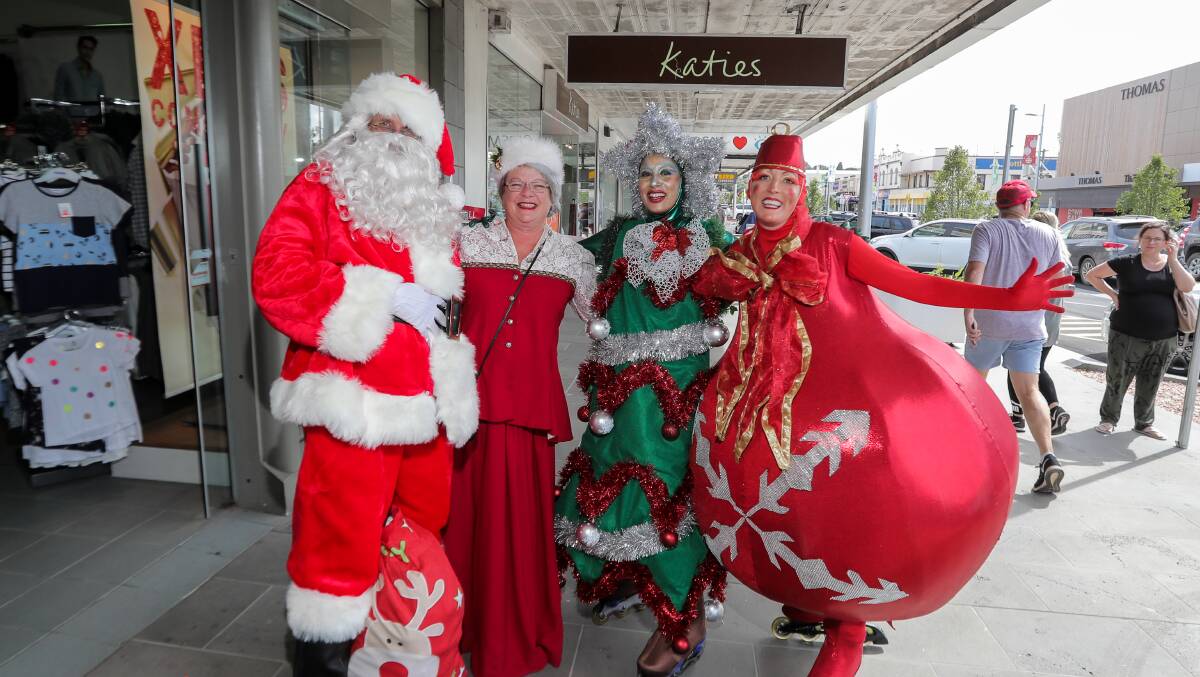 Spreading good cheer: Santa Claus, Mrs Claus, and a rollerblading Christmas Tree and Bauble catch up in Liebig Street. Picture: Rob Gunstone