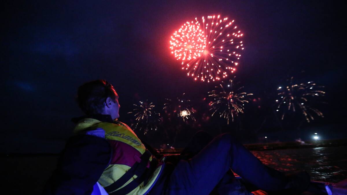 Top show: On water security officer Troy Kersten from Southern Cross Fireworks watches the New Year's Eve fireworks from a boat at the Warrnambool breakwater.