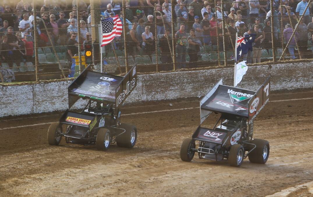 RIVALRY: Cars parade the American and Australian flags during the national anthem on Friday night prior to racing beginning.