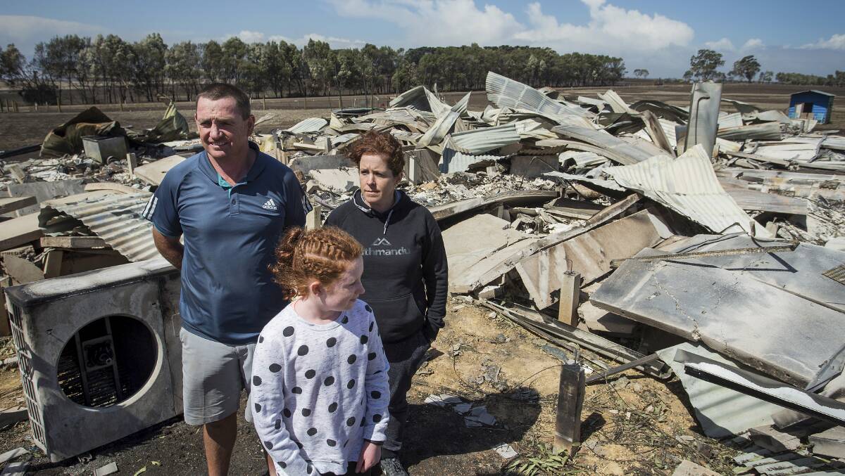In ashes: Phil and Maree Beasley with their daughter Rose: "We got within 500 metres of home and saw pretty much everything there burning." Picture: Paul Jeffers