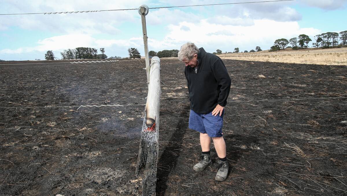 Difference of opinion: Farmer Jack Kenna inspects a snapped power pole that he reckons started the Garvoc fire. Powercor has said it doesn't believe the pole was the cause of the fire. Picture: Christine Ansorge