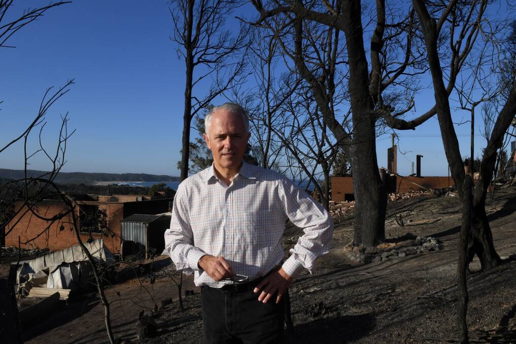 Australian Prime Minister Malcolm Turnbull tours the more than 70 houses and businesses destroyed by a bushfire in the coastal town of Tathra on Monday. 