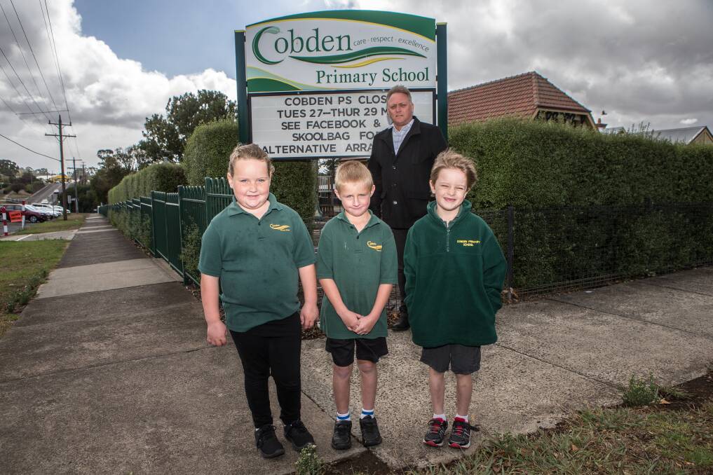SCHOOL'S OUT: Olivia Halliday, 6, Samuel Robertson, 6, and Oliver Rowe, 6, with Cobden Primary School principal Peter Lee. The school is closed for the remainder of the week. Picture: Christine Ansorge