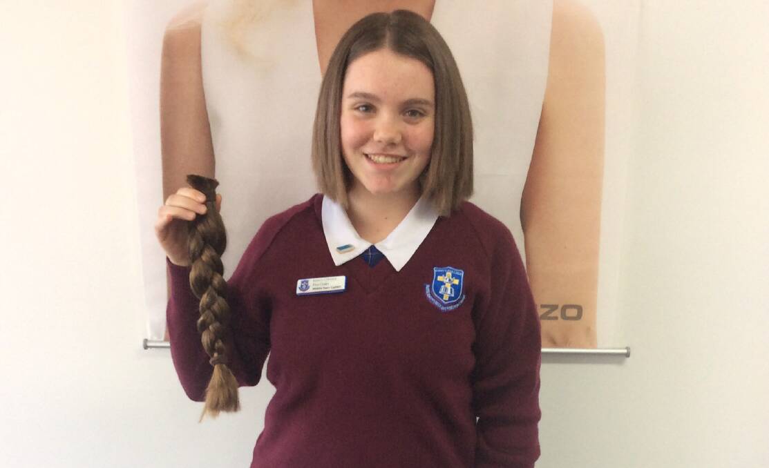 Gone: Elise Drake holds her plat straight after saying farewell to it in the name of a good cause. Her hair was donated to help create wigs for young people.
