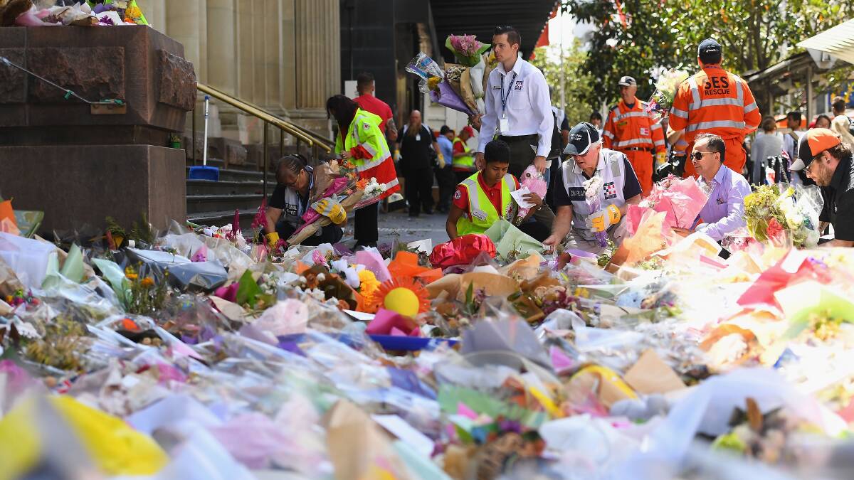 In mourning: The Bourke Street Mall tragedy, which left six people dead and many others injured prompted an outpouring of grief with a sea of floral tributes places at the former post officer building at the end of the mall. 