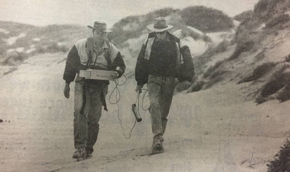 SEARCH: University of New England geophysicists Malcolm Cattach and Peter Clark scour the beach with a magnetometer.