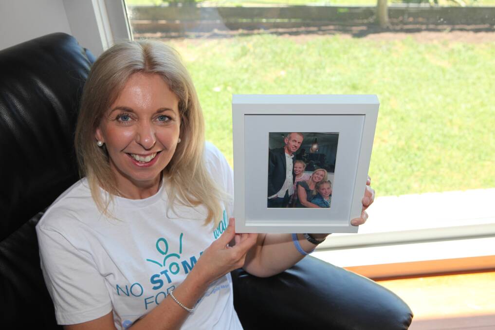 Raising awareness: Paula Groves, with a picture of her husband Darren and 12-year-old twin daughters Charli and Jaz. Darren lost his battle with stomach cancer in August. Family and friends took part in the No Stomach for Cancer charity walk at the weekend.