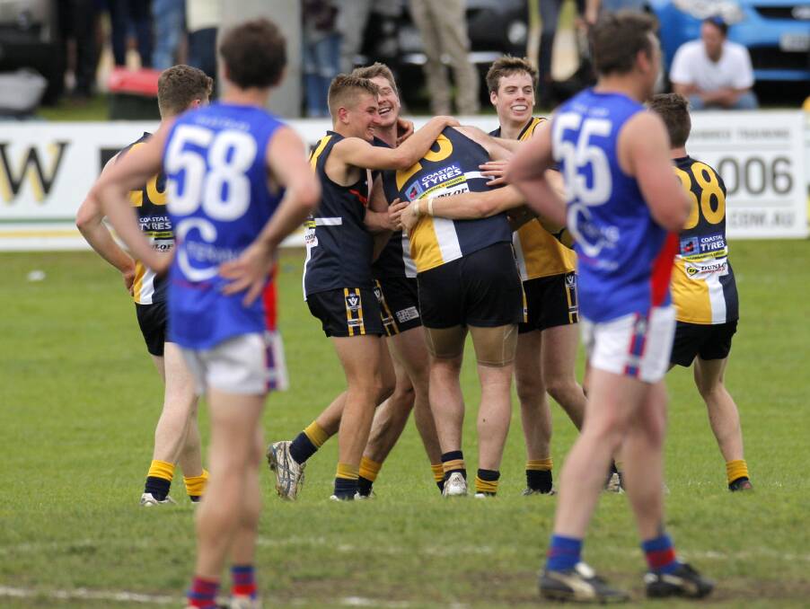 CONTRASTS: North Warrnambool Eagles players celebrate en masse after a goal is kicked, while Terang Mortlake watches on in despair. 