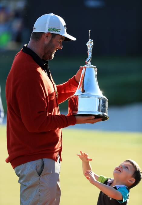 WINNER: Marc Leishman of Australia celebrates with the trophy and one of his sons after finishing on the 18th green during the final round of the Arnold Palmer Invitational. Picture: Getty Images
