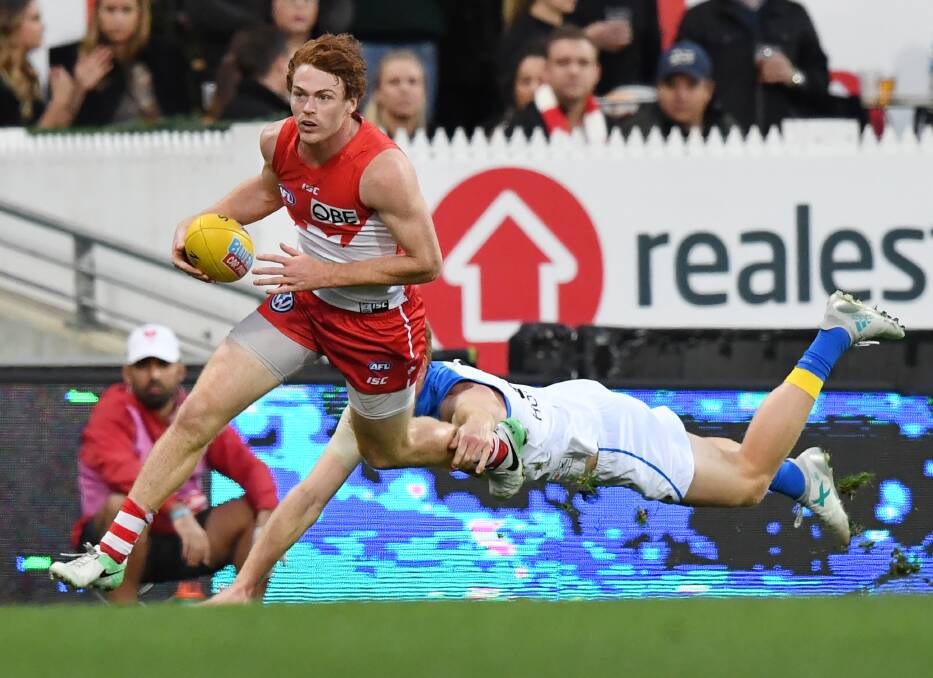 HIGH SPEED: Gary Rohan of the Swans runs past a flying tackle before scoring a goal against Gold Coast. Picture: AAP/David Moir