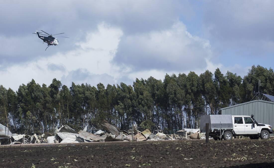 A helicopter surveys the scene of a destroyed property. Picture: Paul Jeffers.