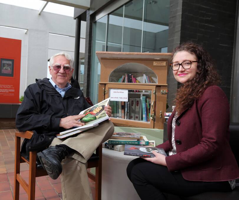 Little library: Nobel Prize winner Dr Russell Schnell and Warrnambool Art Gallery director Vanessa Gerrans share a book in the gallery's courtyard. Picture: Rob Gunstone