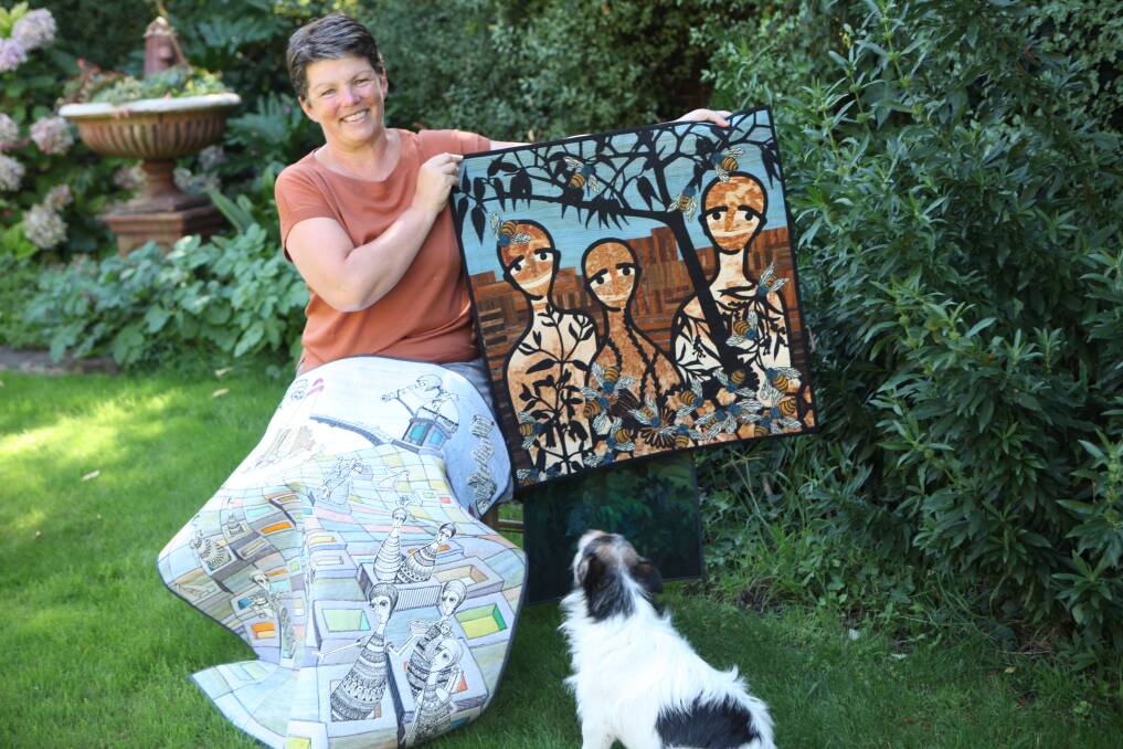 Family support: Warrnambool artist and retired Brauer College teacher Alison Withers displays some of her favourite quilts while family pet dog Frank offers his undivided attention. Picture: Rebecca Riddle