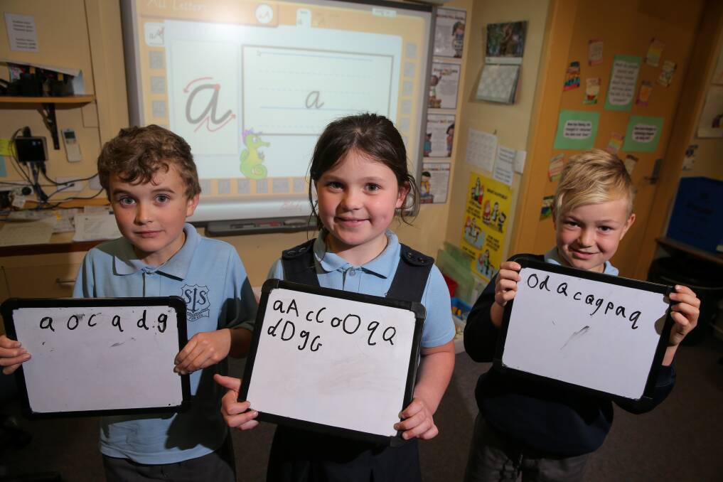 Multimodal learning: Electronic whiteboards are used by St Josephs Primary students Jacob Ward, 8, Edtih Walsh, 8 and Billy Schrama, 7, to reinforce their handwriting skill learning in the classroom. Picture: Rob Gunstone.