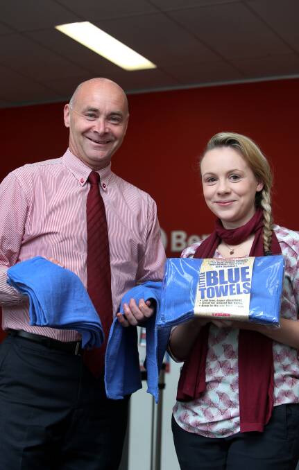 Maroon to blue: Bendigo Bank branch manager Steve Walker and employee Lauren Jackson say the towels are perfect for cleaning, camping or fishing. Picture: Amy Paton