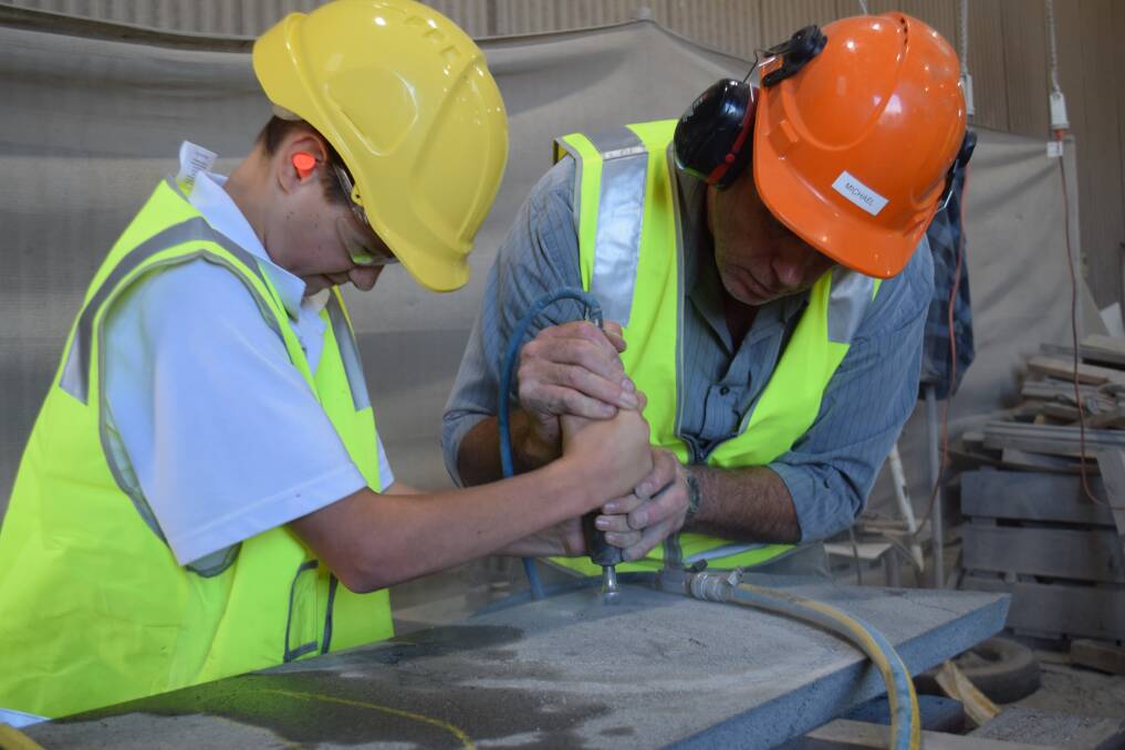 Teamwork: Clontarf Academy member Joel Campbell, 14, and Bamstone's managing director Michael Steel are etching a piece of Indigenous culture to show in Melbourne.