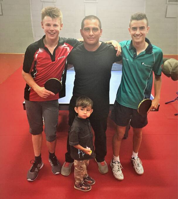 LONG RALLY: Tristan Quarrell (left), Jose Lopez and Joe Sycopoulis take a break from playing ping pong for 24 hours to get a photo with a young fan. 