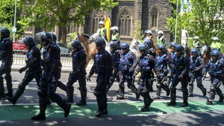 Police officers move towards State Parliament for the rally. Photo: Luis Ascui