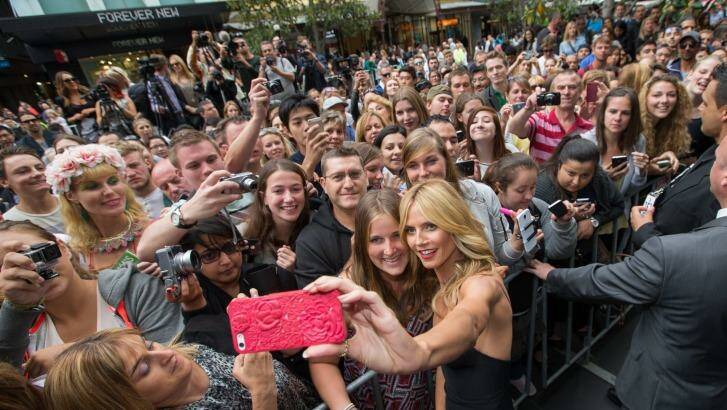 Heidi Klum shares a snap with onlookers in the Bourke Street Mall. Photo: Jason South