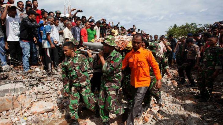 Military personnel and aid workers carry out victims of the Aceh earthquake in Pidie Jaya. Photo: Jefri Tarigan