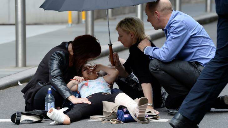 Support is offered to a person injured in Bourke Street. Photo: Justin McManus