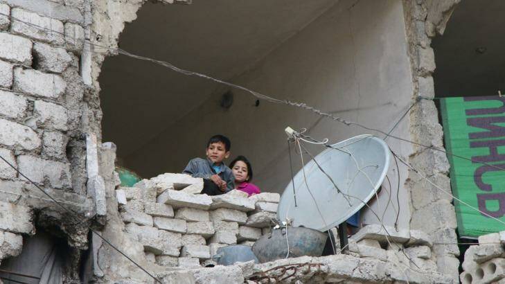 Children peer out from their destroyed home in Aleppo, Syria's largest city. Photo: Komsomolskaya Pravda via AP