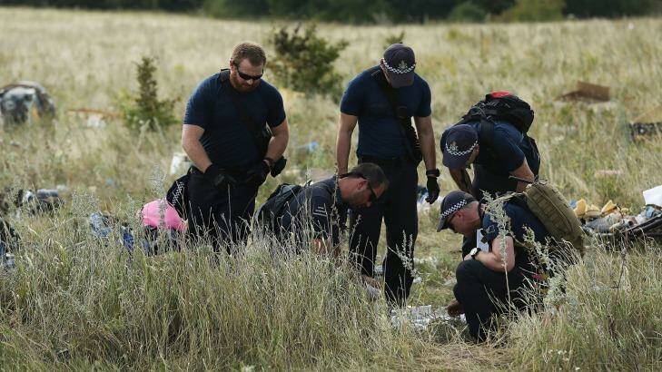 August 2014: Australian Federal Police officers and their Dutch counterparts collect human remains from the MH17 crash site in the fields outside the village of Grabovka in rebel-held eastern Ukraine.  Photo: Kate Geraghty