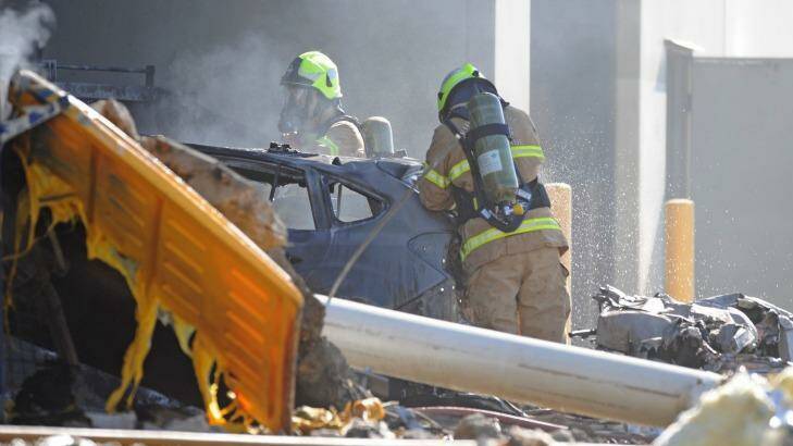 Emergency services personnel work at the  crash scene. Photo: Joe Castro