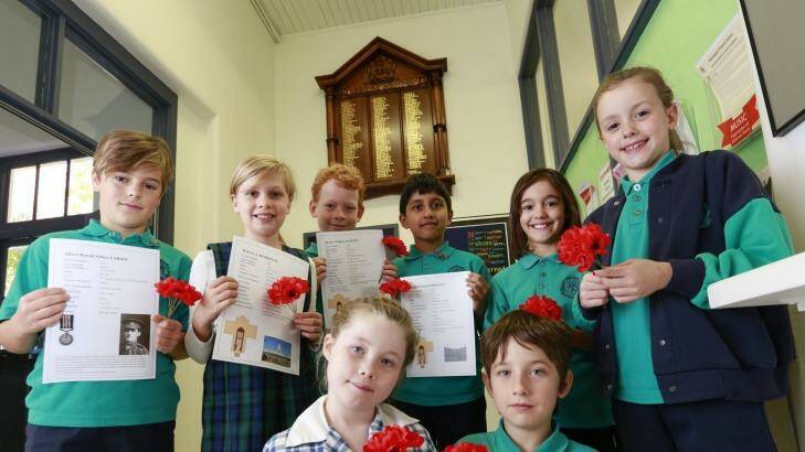 Grade 3 and 4 students at the Flemington Primary School with the ANZAC  honour board, which they received a grant to restore. Photo: Eddie Jim