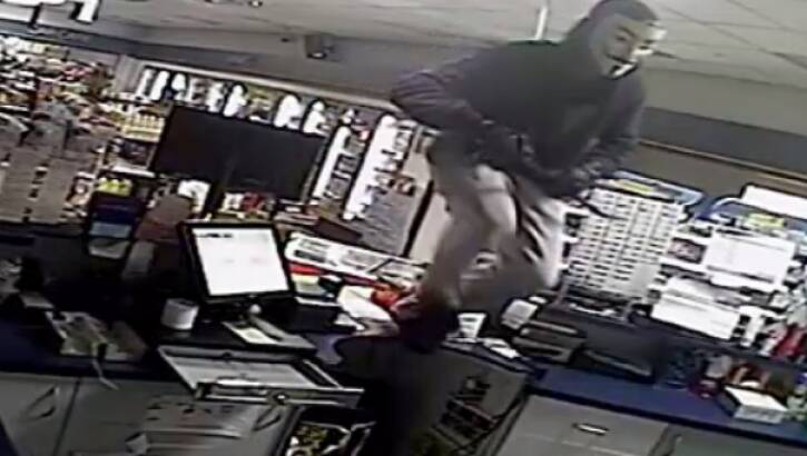 A masked man breaks into a service station in Heidelberg Heights. Photo: Victoria Police