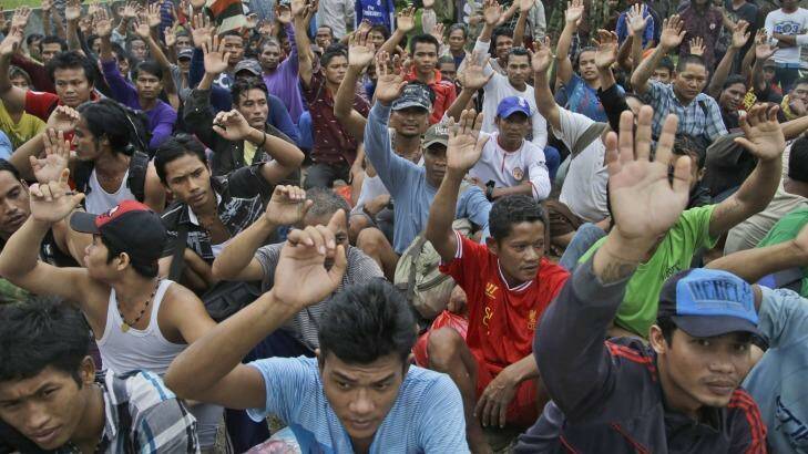 Rescued Burmese fishermen raise their hands as they are asked who among them wants to go home from their location at Benjina, Aru Islands, Indonesia.