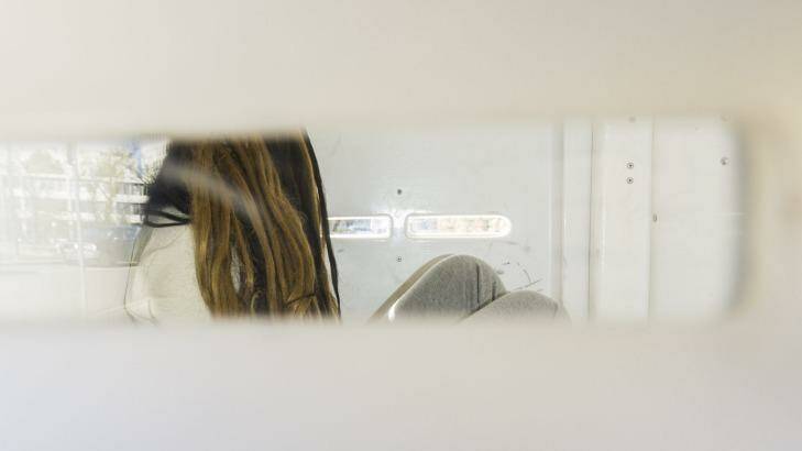 Charged: The 23-year-old woman arrives at court in the back of a police van. Photo: Rohan Thomson