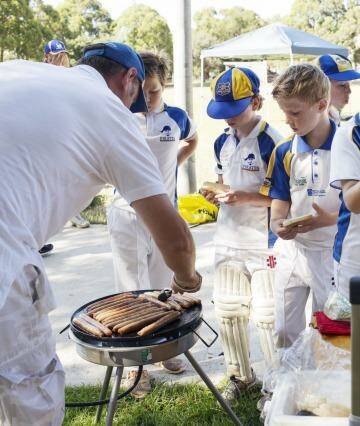 After the match: Under 11s hit the sausage sizzle.  Photo: James Brickwood