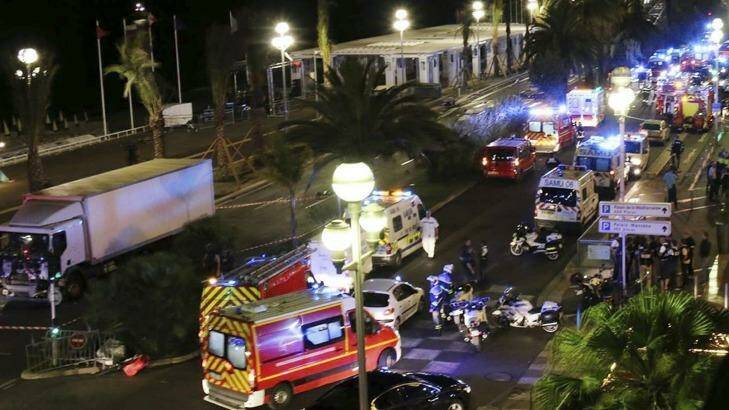 Emergency services vehicles work on the scene after a truck, left, plowed through Bastille Day revellers in the French resort city of Nice, France. Photo: Sasha Goldsmith