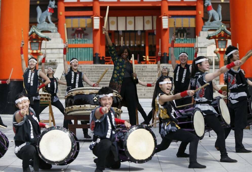 U.S. first lady Michelle Obama (C) beats a Japanese traditional taiko drum with members from Akutagawa High School Taiko Club in front of the main gate, as she visits Fushimi Inari Shinto Shrine in Kyoto, western Japan March 20, 2015. Michelle Obama flew in to Japan on Wednesday for a three-day visit as part of the Let Girls Learn international girls education initiative. REUTERS/Issei Kato            TPX IMAGES OF THE DAY Photo: ISSEI KATO