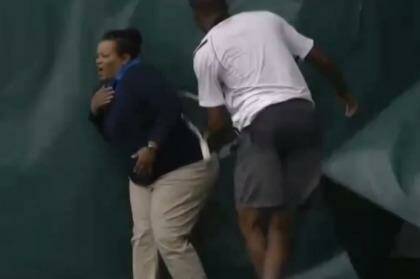 The lineswoman reacts as King's racquet hits her in the back.