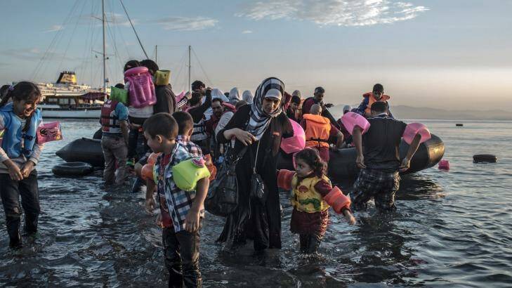 Syrian refugees wade ashore after arriving via a motorised inflatable raft on the island of Kos in Greece. Photo: Daniel Etter