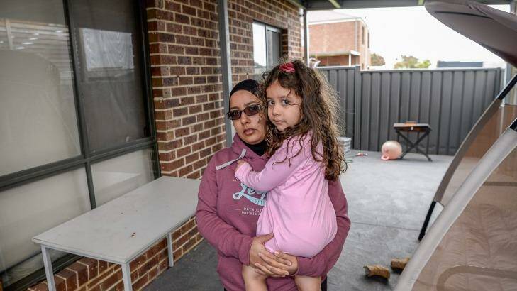 Jamal Elhussein lives just a few doors down from the site with the dumped asbestos from the Corkman Pub. She is worried about the possible exposure to her family. With daughter Asmaa in their back porch where dust has settled since the dumping.  Photo: Justin McManus