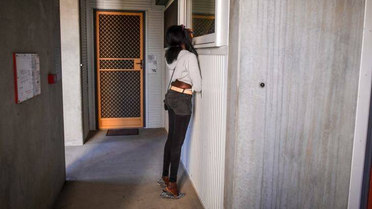 Akiir Muo peers through a window at her boyfriend's mother's home in Windsor.  Photo: Eddie Jim