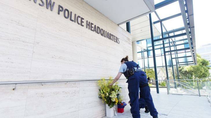 Police officers lay flowers at NSW Police State Crime Command in Parramatta where a boy gunned down Curtis Cheng, who worked for the police finance department. Photo: James Brickwood
