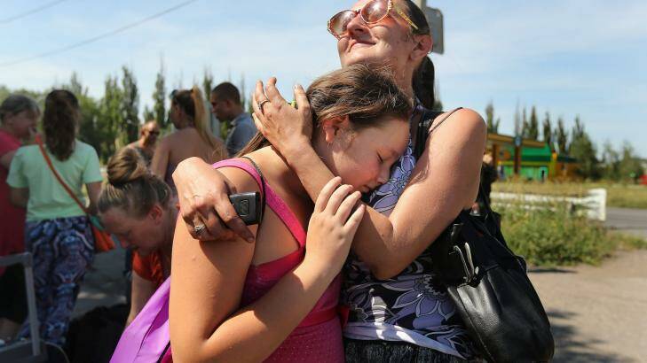 Marsha (right) embraces her scared daughter Lylia  as they join other people from Shakhtersk fleeing the continued heavy shelling of the town half way between Donetsk and the MH17 crash site. Photo: Kate Geraghty