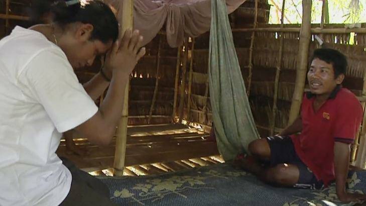 Former slave fisherman Kyaw Naing, left, pays respects after he is reunited with his brother Kyaw Oo at his home in Myaung Mya, Myanmar.