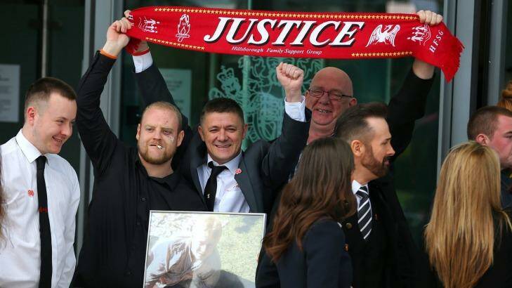 Relatives of the Hillsborough victims hold up a "Justice" scarf as they depart Birchwood Park after hearing the conclusions of the Hillsborough inquest on April 26, 2016. Photo: DAVE THOMPSON