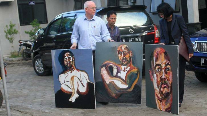 Bali nine lawyer, Julian McMahon, with three recent paintings by Myuran Sukumuran, among them one marked "Self Portrait, 72 hours just started" as Sukumuran began the countdown to his execution. Photo: Amilia Rosa